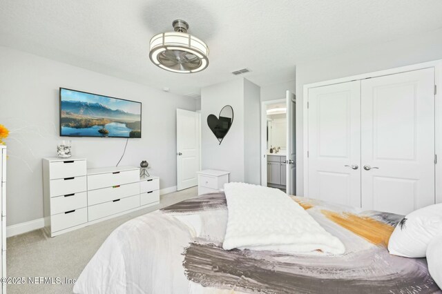 bedroom featuring baseboards, visible vents, connected bathroom, light colored carpet, and a closet