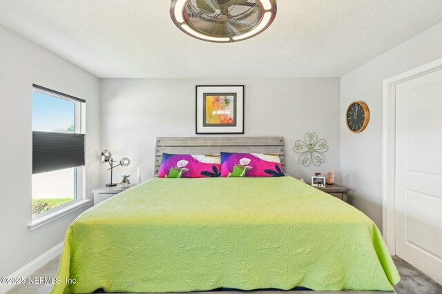 bedroom with baseboards, multiple windows, and carpet flooring