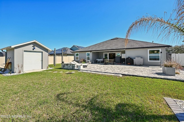 rear view of house with stucco siding, fence, an outdoor structure, and a patio