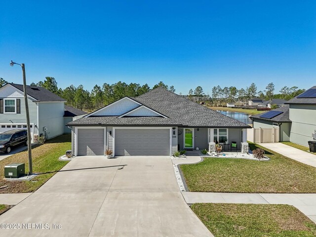 ranch-style home featuring an attached garage, a shingled roof, fence, concrete driveway, and a front lawn