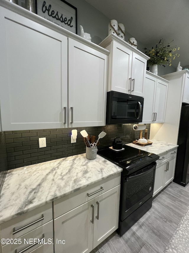 kitchen featuring black appliances, white cabinetry, light wood-style floors, and backsplash