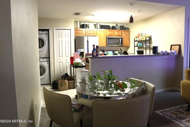 carpeted dining area with stacked washer and dryer