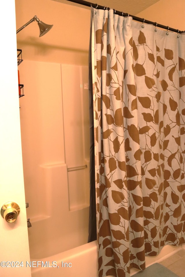 bathroom with shower / bath combination with curtain and tile patterned floors