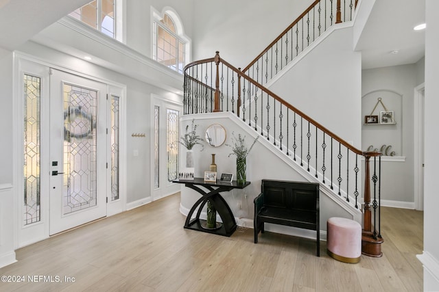 entryway with a towering ceiling and light hardwood / wood-style floors