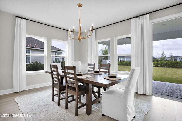 dining area with an inviting chandelier and light hardwood / wood-style flooring