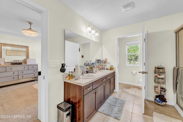 bathroom featuring toilet, vanity, tile patterned floors, and a textured ceiling