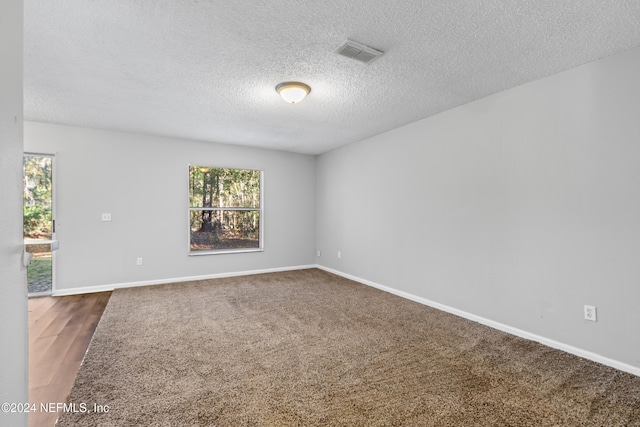 spare room featuring a textured ceiling and hardwood / wood-style flooring