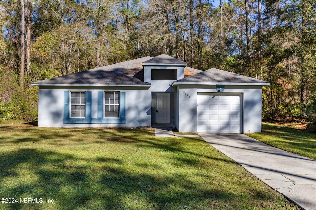 view of front facade with a front yard and a garage