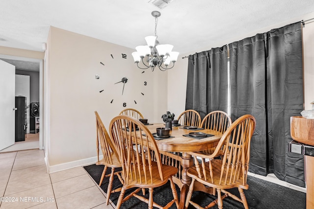 dining room with light tile patterned floors, a textured ceiling, and an inviting chandelier