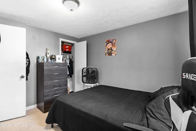 carpeted bedroom featuring a textured ceiling and a closet