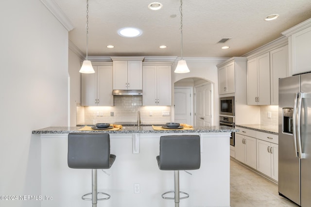 kitchen with pendant lighting, crown molding, light stone countertops, white cabinetry, and stainless steel appliances