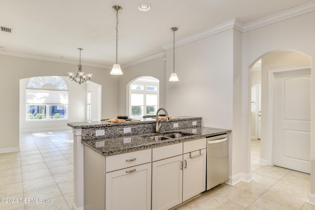 kitchen with dishwasher, dark stone counters, hanging light fixtures, sink, and white cabinetry