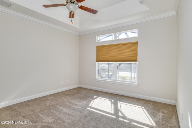 carpeted empty room with a wealth of natural light, crown molding, and ceiling fan