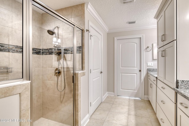 bathroom featuring ornamental molding, a textured ceiling, vanity, tile patterned flooring, and a shower with shower door