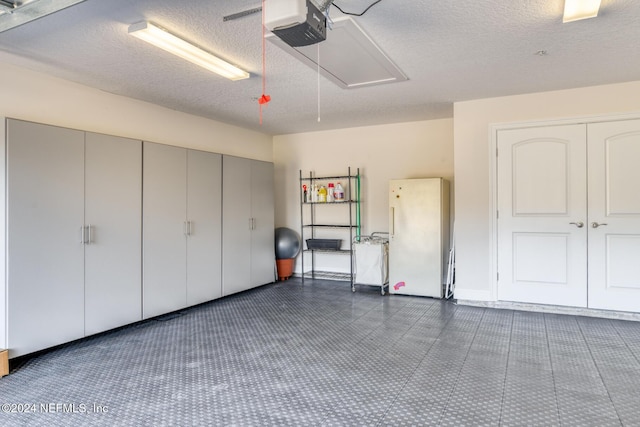 garage with white refrigerator and a garage door opener