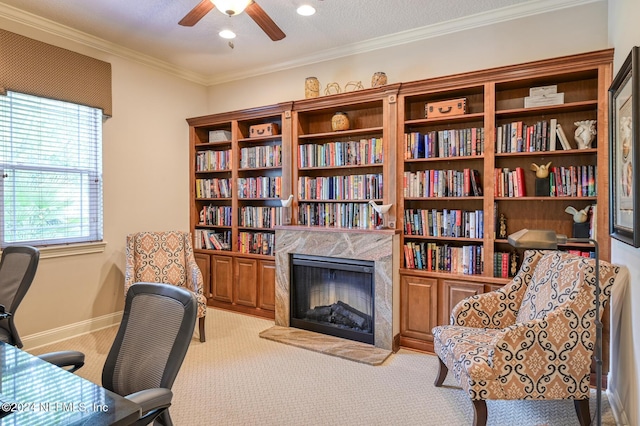 carpeted office space with a high end fireplace, a textured ceiling, ceiling fan, and crown molding