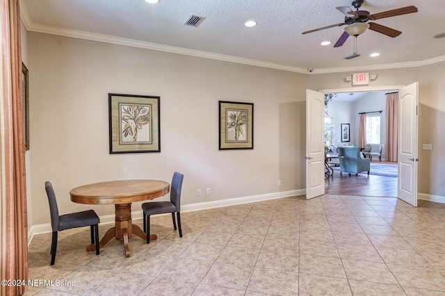 dining area featuring crown molding, light tile patterned floors, ceiling fan, and a textured ceiling