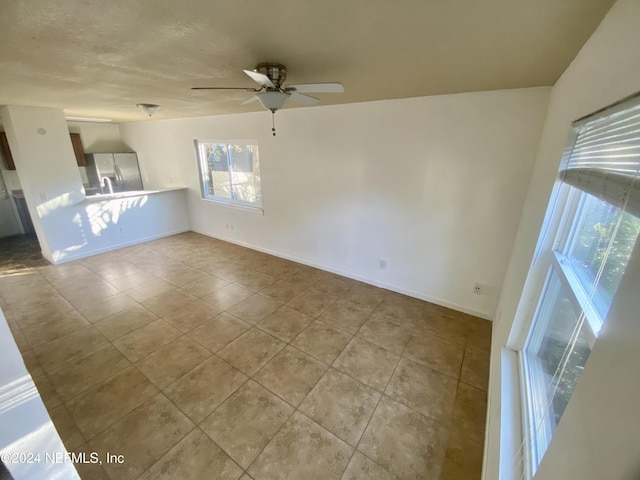 spare room featuring light tile patterned floors and ceiling fan