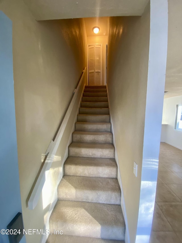 staircase featuring tile patterned flooring