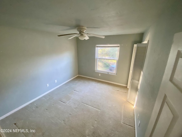 carpeted empty room featuring ceiling fan