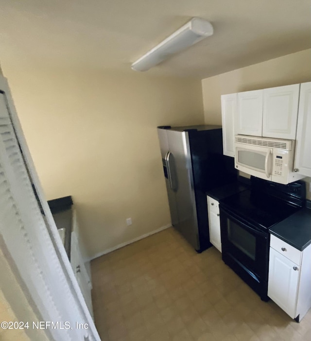 kitchen featuring electric range, white cabinets, and stainless steel fridge with ice dispenser