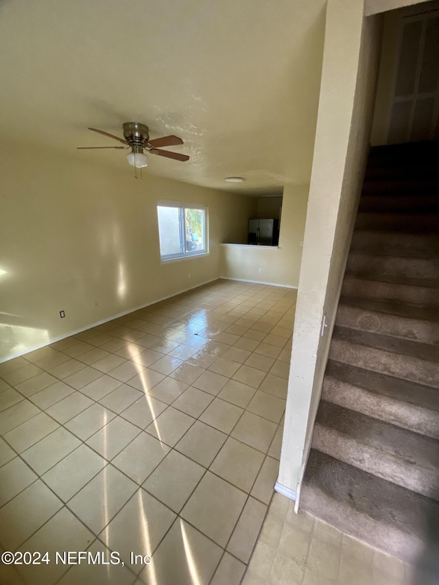 stairs with tile patterned flooring and ceiling fan