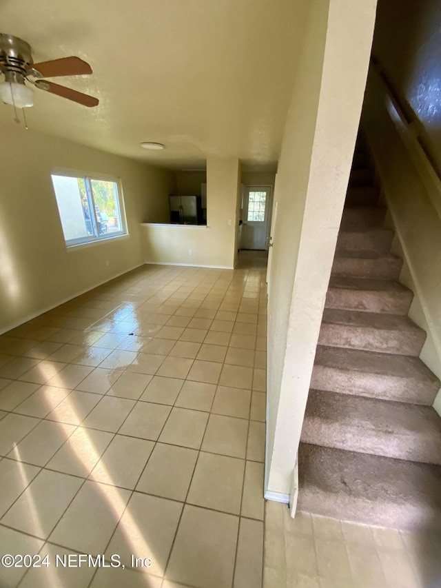 staircase featuring tile patterned floors and ceiling fan