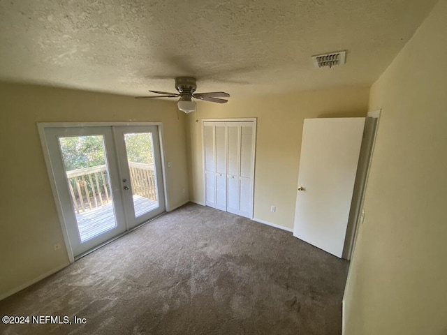 unfurnished bedroom with access to exterior, ceiling fan, french doors, dark colored carpet, and a closet