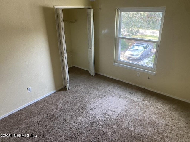 unfurnished bedroom featuring carpet, a closet, and multiple windows