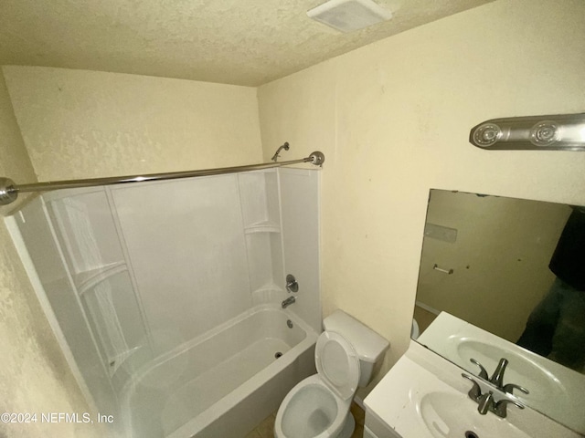 full bathroom featuring vanity, shower / bathing tub combination, a textured ceiling, and toilet