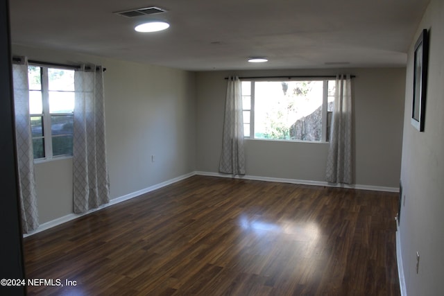 unfurnished room featuring dark hardwood / wood-style floors and a healthy amount of sunlight