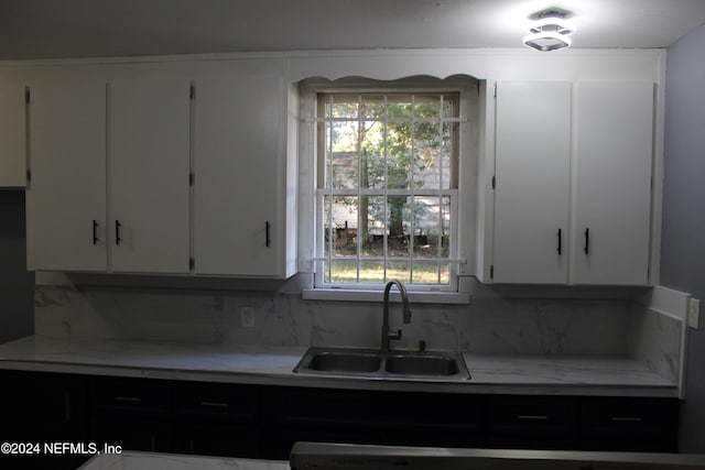 kitchen featuring white cabinetry, sink, and decorative backsplash