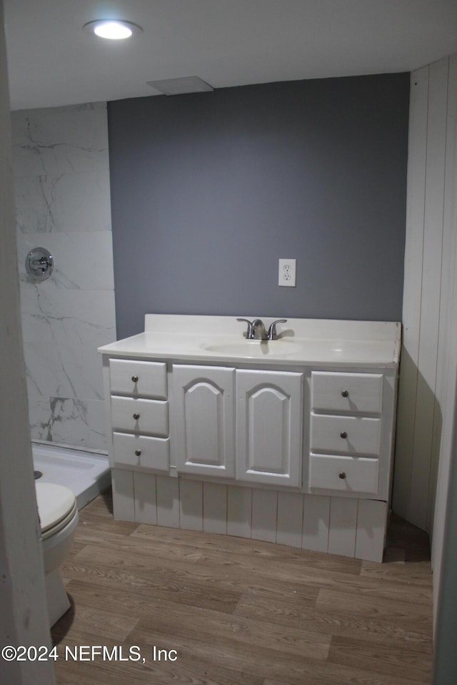 bathroom with vanity, hardwood / wood-style floors, toilet, and a shower