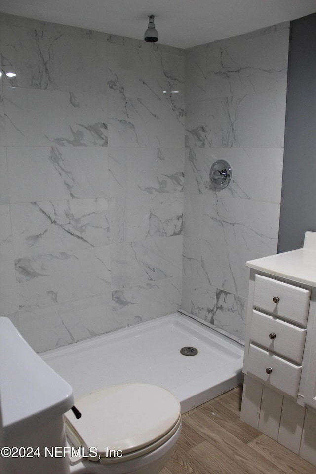 bathroom featuring vanity, wood-type flooring, toilet, and walk in shower