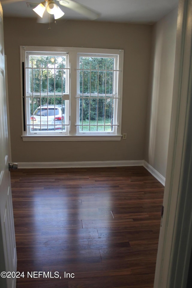 spare room with dark hardwood / wood-style flooring and ceiling fan