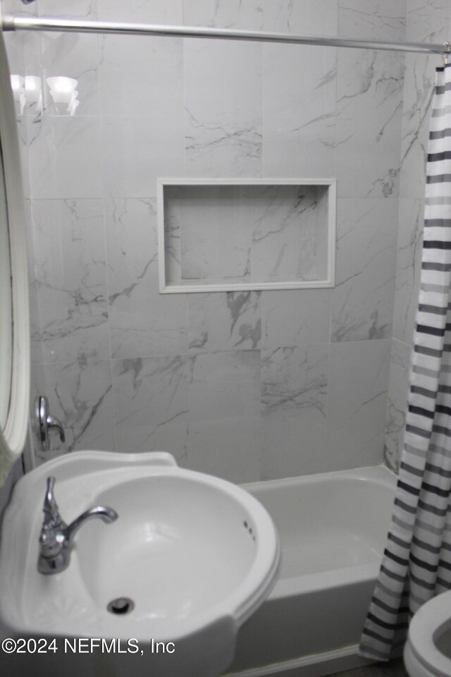 bathroom with shower / tub combo with curtain and sink