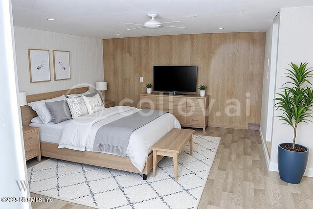 bedroom featuring ceiling fan, wooden walls, and light hardwood / wood-style flooring