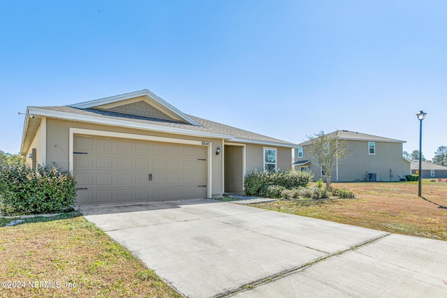 ranch-style house featuring a garage and a front lawn