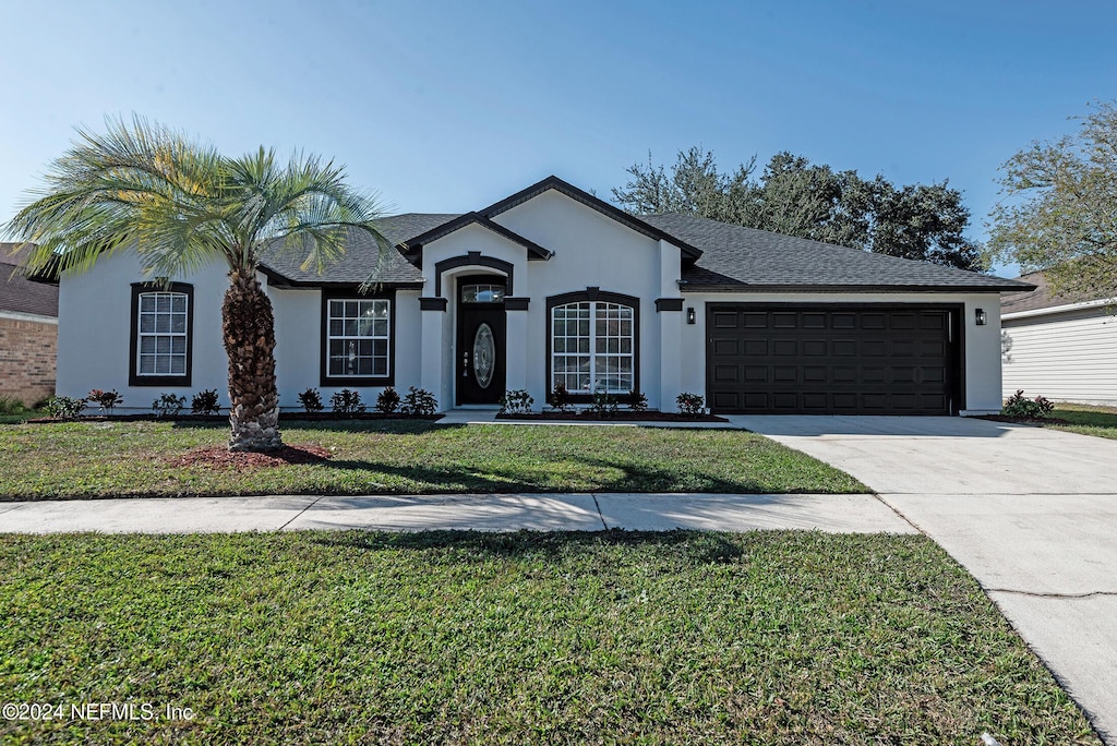 single story home with a front yard and a garage