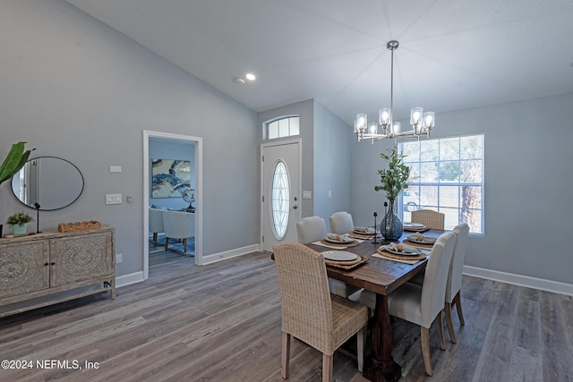 dining space with dark hardwood / wood-style floors, vaulted ceiling, and a notable chandelier