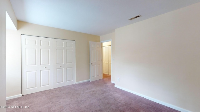 unfurnished bedroom featuring carpet floors and a closet