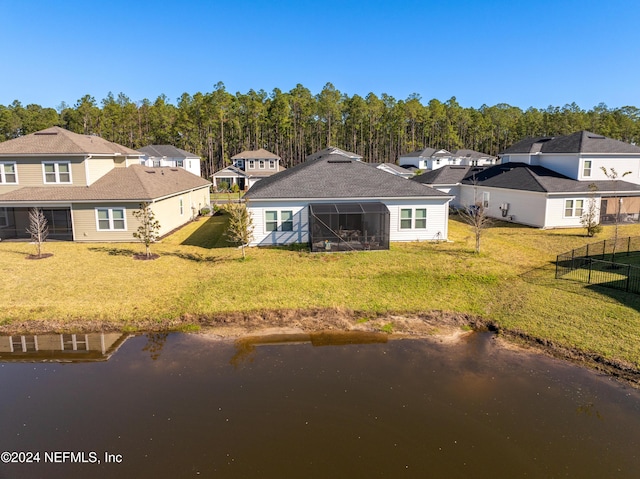 rear view of property with a yard and a water view