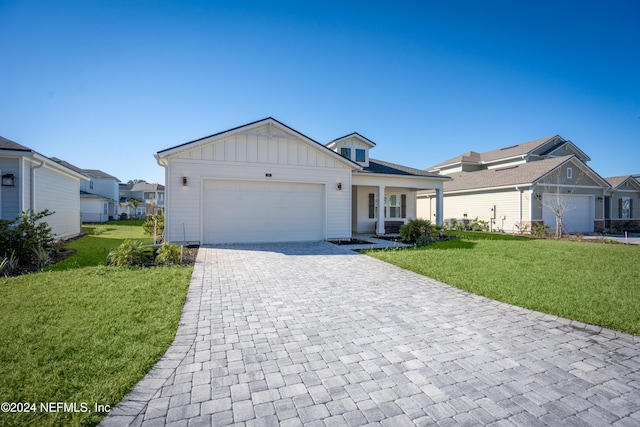 view of front of property featuring a front yard, a porch, and a garage