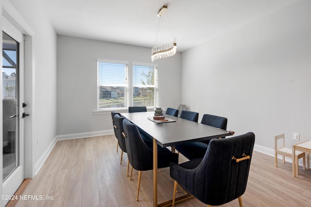 dining space featuring a notable chandelier and light wood-type flooring