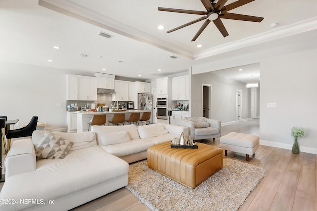 living room with ceiling fan, light hardwood / wood-style flooring, and crown molding