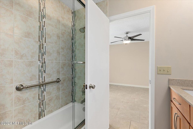 bathroom with vanity, a textured ceiling, enclosed tub / shower combo, and ceiling fan