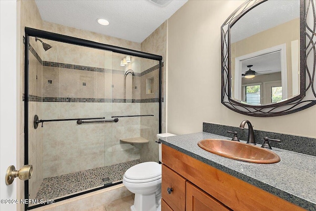 bathroom featuring vanity, a shower with shower door, toilet, and a textured ceiling