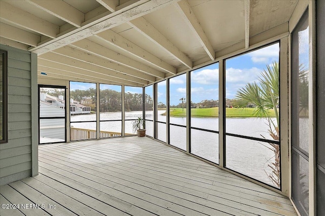 unfurnished sunroom featuring a water view