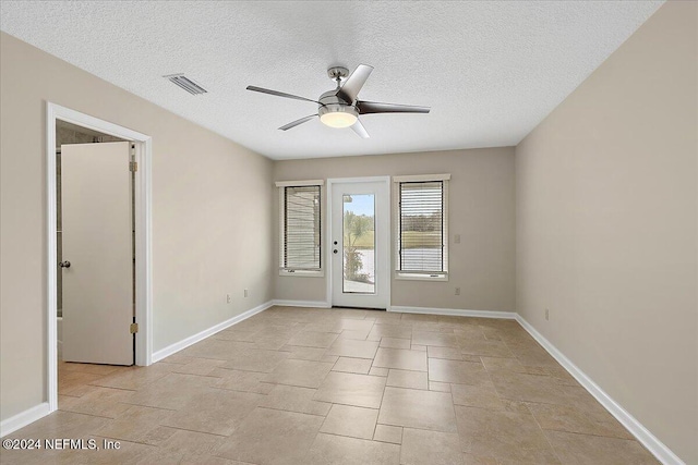 unfurnished room with a textured ceiling and ceiling fan