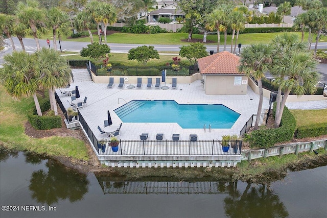 view of pool with a patio and a water view